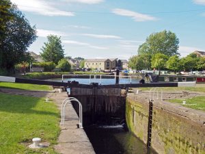 A view of the lock gates at the entrance to Brighouse canal basin and moorings on the calder and hebble navigation canal in calderdale West Yorkshire